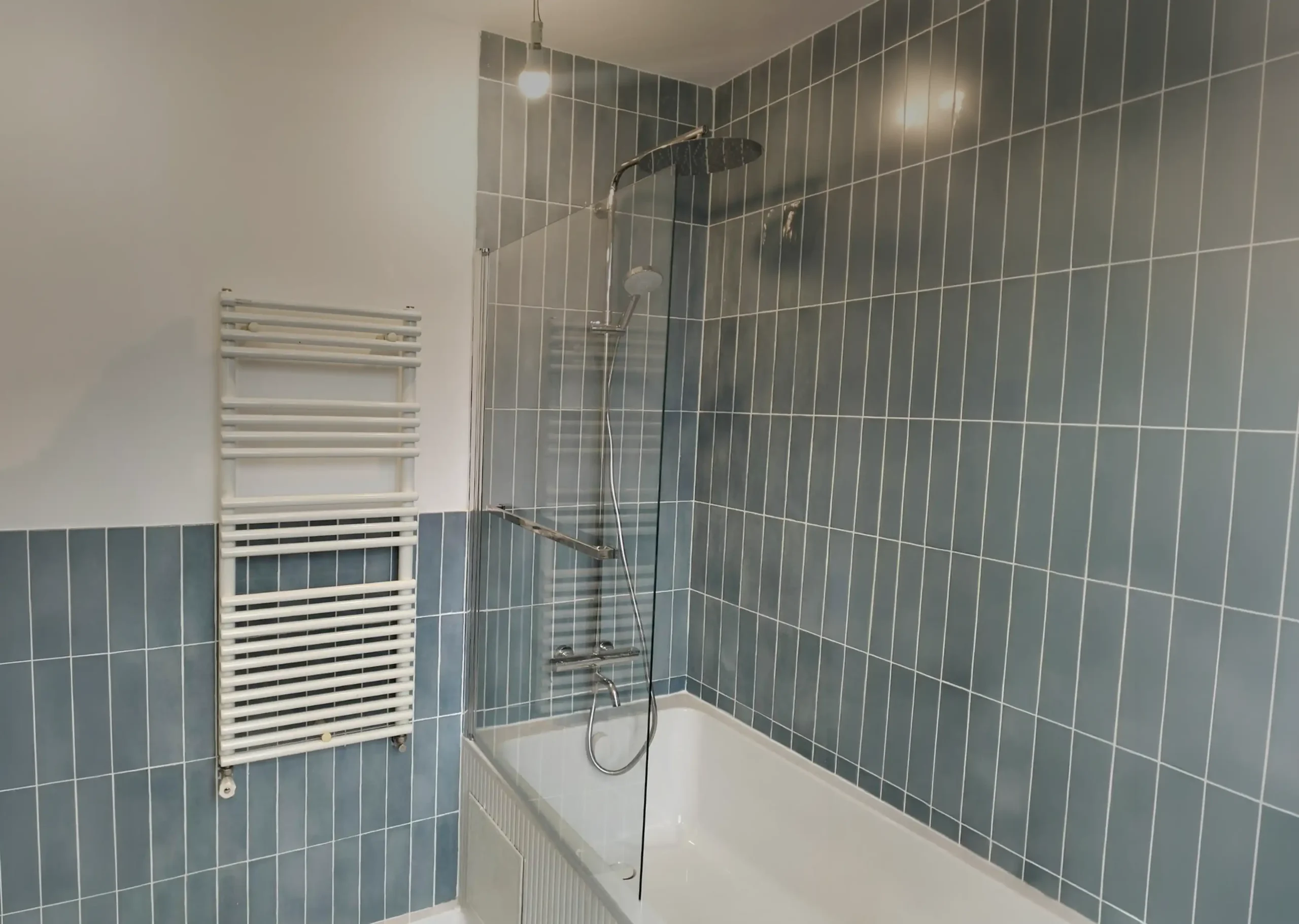 Rénovation terminée d'une baignoire dans une salle de bain à Vanves par Helmo Rénovation