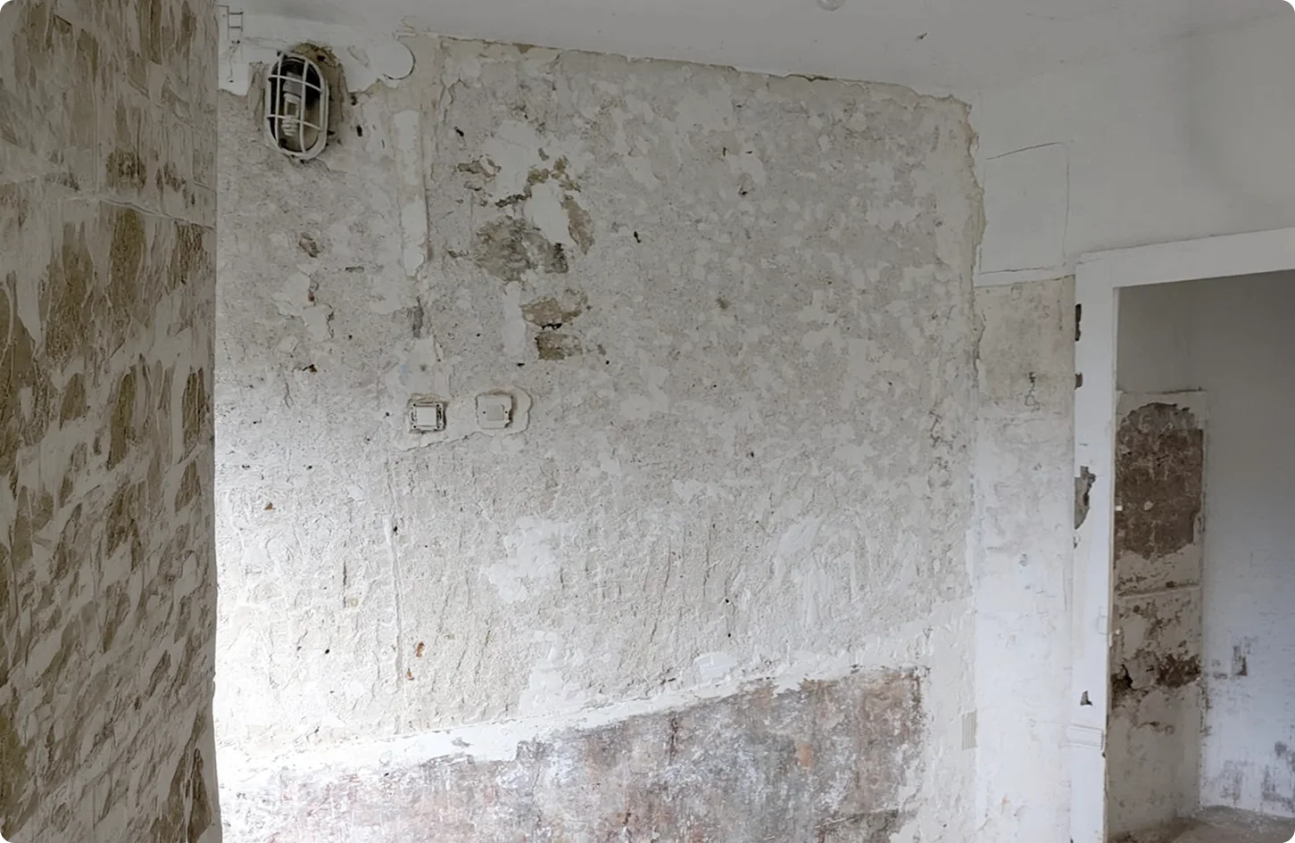 Préparation des murs avant peinture dans un chantier de rénovation d'intérieur à Alfortville, montrant les détails de maçonnerie.
